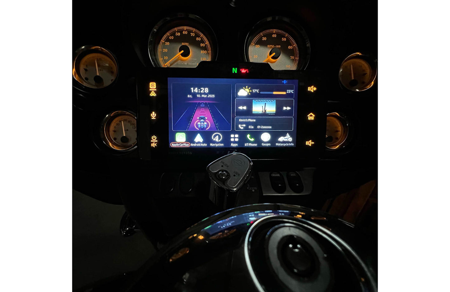 Car dashboard with digital display and analog gauges in a dark setting