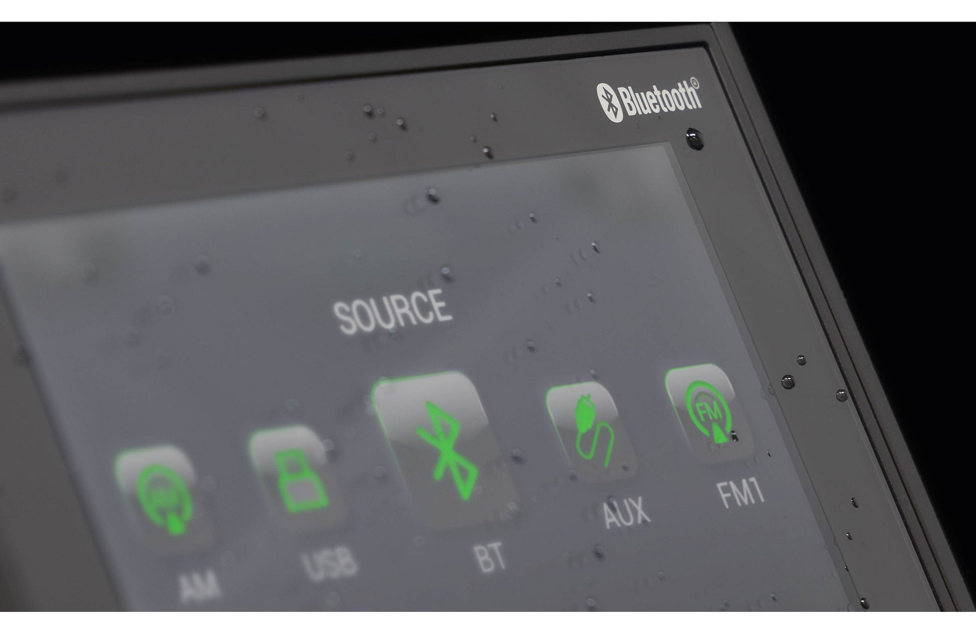 Close-up of a car stereo control panel with Bluetooth and source options.